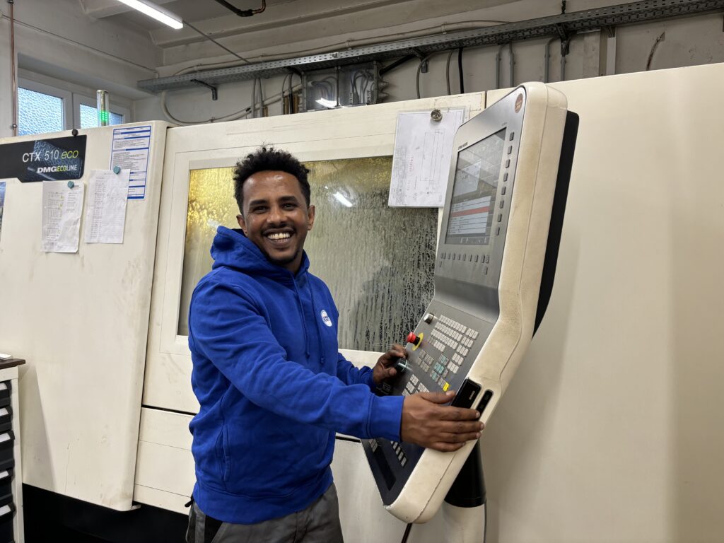 Mitarbeiter bedient eine CNC-Maschine in der Fertigung von Sondergetrieben und Präzisionsbauteilen bei Emil Kreiskott.